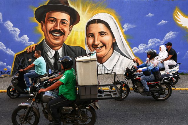 Motorcyclists ride in front of a mural painted in honor of the canonization of Blessed José Gregorio Hernández and Blessed Carmen Rendiles Martínez on October 18, 2025 in Caracas, Venezuela. Mother Carmen and José Gregorio Hernández Cisneros, a doctor, scientist, known as the “Doctor of the Poor” will be canonized by Pope Leo XIV during a solemn Mass at St. Peter's Basilica on October 19, 2025, and will be Venezuela's first two saints. (Photo by Jesus Vargas/Getty Images)