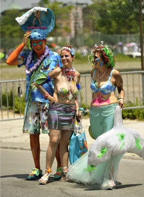 Parade participants arrive in costume for the 31st Annual Mermaid Parade at New York's Coney Island on June 22, 2103. Over 700,00 people are exptected to turn out for the  scantily clad parade.       AFP PHOTO / TIMOTHY CLARY        (Photo credit should read TIMOTHY CLARY/AFP/Getty Images)