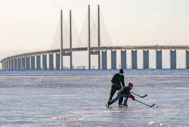 Skaters play hockey on the ice that settled on the Oresund strait, Wednesday February 10, 2021, at Bunkeflostrand a suburb of Malmo, Sweden, south of the Oresund Bridge. (Photo by Johan Nilsson/TT via AP Photo)