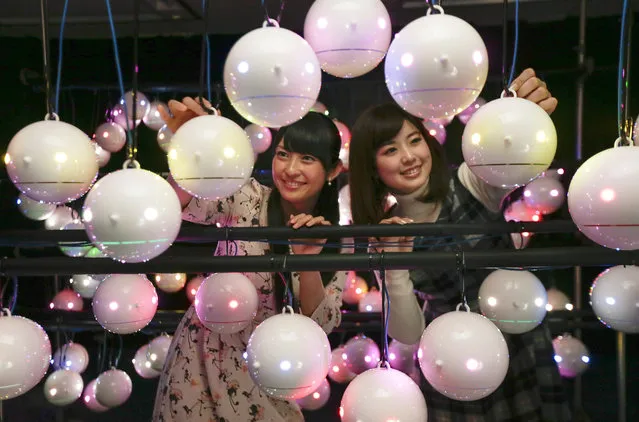 Weathernews casters Airi Yamagishi (L) and Akane Fujioka inspect pollen robots, observation equipment measuring pollen load ahead of the start of the hay-fever season at headquarters of Japan's weather information service company Weathernews at Makuhari in Chiba, east of Tokyo, Japan, 28 January 2015. Many people suffer from hay fever from early next month as the people are allergic to pollen. (Photo by Kimimasa Mayama/EPA)