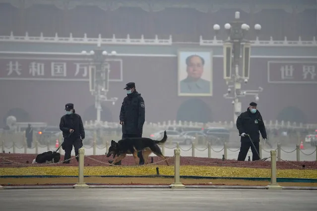Police officers use sniffer dogs to check on Tiananmen Square before delegates arrive for the opening session of China's National People's Congress (NPC) at the Great Hall of the People in Beijing, Friday, March 5, 2021. China's No. 2 leader has set a healthy economic growth target and vowed to make this nation self-reliant in technology amid tension with Washington and Europe over trade and human rights. (Photo by Andy Wong/AP Photo)