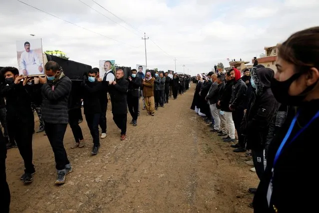 Mourners carry remains of people from the minority Yazidi sect, who were killed by Islamic State militants, after they were exhumed from a mass grave, to re-bury them in Kojo, Iraq on February 6, 2021. In August 2014, Islamic State fighters surrounded the village of Kojo in Sinjar district, northern Iraq, rounded up Yazidi residents and slaughtered several hundred of them. (Photo by Thaier al-Sudani/Reuters)