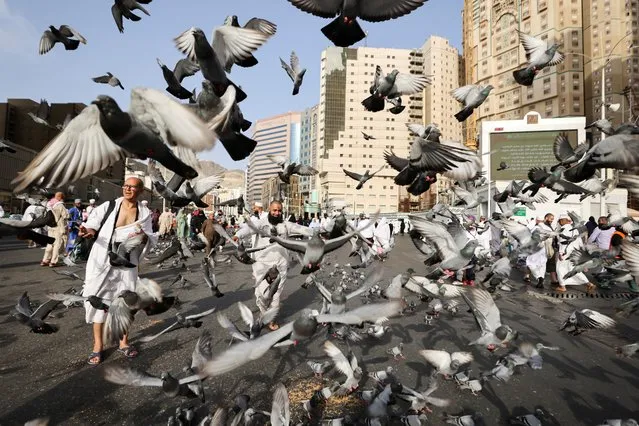Doves fly around Muslim pilgrims outside the holy Kaaba, as people start arriving to perform the annual Haj in the Grand Mosque, in the holy city of Mecca, Saudi Arabia on June 24, 2023. (Photo by Mohamed Abd El Ghany/Reuters)