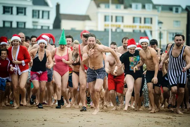 People take part in the annual Exmouth Christmas day swim, at Exmouth beach, in Devon, England, December 25, 2015. (Photo by Ben Birchall/AP Photo)