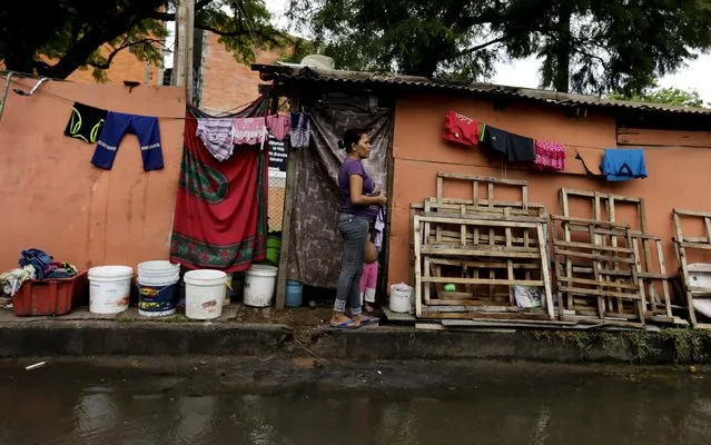 A woman stands in front of makeshift shelter for victims of the floods in Asuncion, Paraguay, December 29, 2015. (Photo by Jorge Adorno/Reuters)