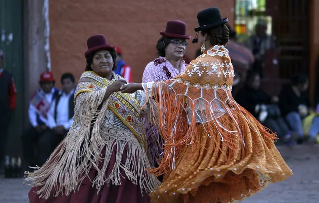 In this Sunday, August 5, 2018 photo, steward Libia Espinoza, left, dances with transgenders Coco and Jessi during festivities honoring Our Lady of Copacabana, in Cuzco, Peru. Espinoza is credited with the first Cuzco celebration venerating the Bolivian virgin, who she believes cured her of her kidney problems. (Photo by Martin Mejia/AP Photo)