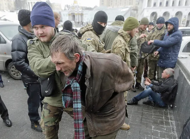 A patrol of Ukrainian policemen and volunteer battalions members arrest men, who are suspected of terrorism on the Independence square in Kiev, Ukraine, 09 February 2015. (Photo by Sergey Dolzhenko/EPA)