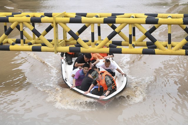 In this photo released by Xinhua News Agency, residents are evacuated from flooded areas in Zhuozhou in northern China's Hebei Province on Wednesday, August 2, 2023. A highway bridge in northern China collapsed due to flash floods triggered by heavy rains, and two cars fell into the river, state media reported Thursday, as parts of China are experiencing the worst floods in decades. (Photo by Mu Yu/Xinhua via AP Photo)