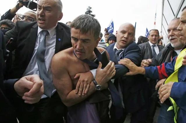 File photo of a shirtless Xavier Broseta (2ndL), Executive Vice President for Human Resources and Labour Relations at Air France, who was evacuated by security after employees interrupted a meeting with representatives staff at the Air France headquarters building at the Charles de Gaulle International Airport in Roissy, near Paris, France, in this picture taken October 5, 2015. Three people were given suspended prison sentences, November 30, 2016, of three to four months after being found guilty of violent conduct when Air France executives had their shirts ripped to shreds last year by employees furious over planned job cuts. (Photo by Jacky Naegelen/Reuters)