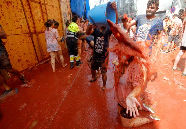 Revellers play with tomato pulp during the annual Tomatina festival in Bunol, near Valencia, Spain on August 29, 2018. (Photo by Heino Kalis/Reuters)
