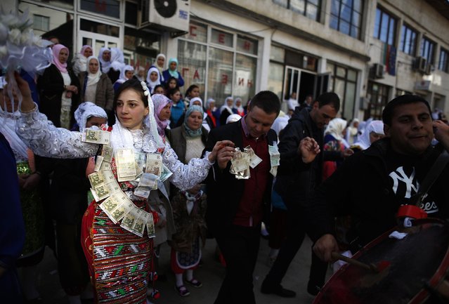 Bulgarian Muslims bride Fikrie Bindzheva (L) dances next to her groom Azim Liumankov during their wedding ceremony in the village of Ribnovo, in the Rhodope Mountains, February 15, 2015. (Photo by Stoyan Nenov/Reuters)