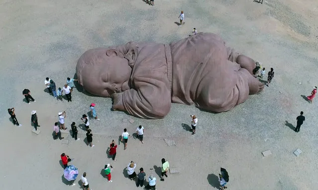 Aerial photo of the sculpture “Son of the Earth” on the Gobi Beach in Guazhou, Jiuquan, Gansu province, China, August 13, 2023. The main body is a giant baby lying on the ground and sleeping peacefully. The material is coarse red sandstone. The main body of the sculpture is 15 meters long, 4.3 meters high and 9 meters wide. (Photo by VCG/Future Publishing via Getty Images)