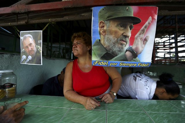 Images of Cuba's late President Fidel Castro hang in a store as the town prepares for the arrival of the caravan carrying Castro's ashes in Guimaro, Cuba, December 1, 2016. (Photo by Ivan Alvarado/Reuters)