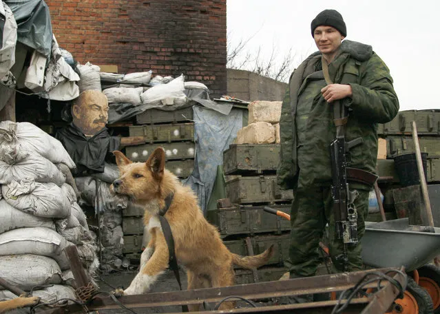 A Pro-Russian separatist with a dog stands at his position on a territory close to Gorlovka, Donetsk area, Ukraine, 18 January 2016. US Secretary of State John Kerry and his Russian counterpart, Sergei Lavrov, have agreed to meet on January 20 in Zurich for talks to focus on the conflicts in Ukraine and Syria, the Russian Foreign Ministry said Thursday in a statement on its website. (Photo by Alexander Ermochenko/EPA)