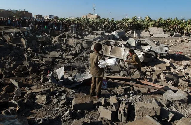 Yemeni civilians stand at the site of a Saudi air strike against Huthi rebels near Sanaa Airport on March 26, 2015, which killed at least 13 civilians. Saudi warplanes bombed Huthi rebels in Yemen, launching a military intervention by a 10-nation coalition to prevent the fall of embattled President Abedrabbo Mansour Hadi. (Photo by Mohammed Huwais/AFP Photo)