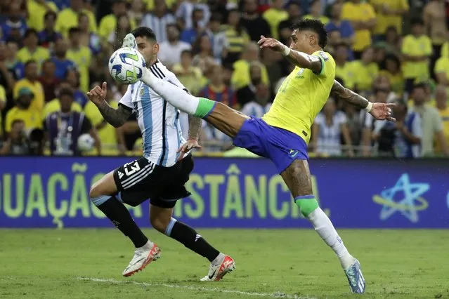 Brazil's Raphinha stretches for a ball challenged by Argentina's Cristian Romero during a qualifying soccer match for the FIFA World Cup 2026 at Maracana stadium in Rio de Janeiro, Brazil, Tuesday, November 21, 2023. (Photo by Bruna Prado/AP Photo)