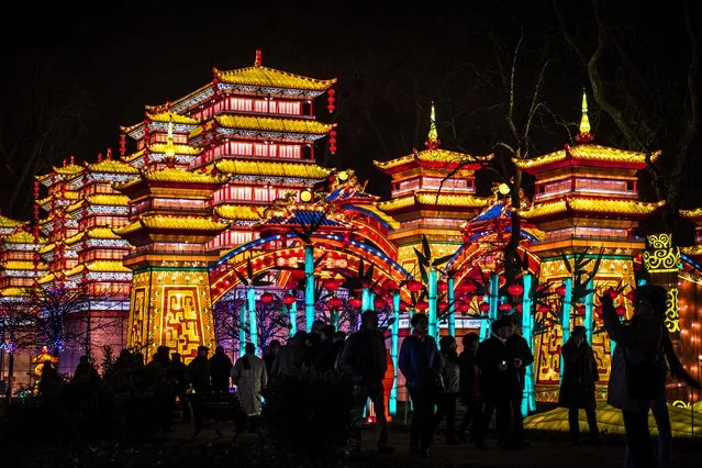 Visitors stand in front of monumental silk lanterns depicting a palace, installed at the Foucaud Park in Gaillac, southwestern France, during the Lantern Festival, on December 12, 2018. Monumental silk sculptures are exhibited in Gaillac from December 1, 2018 to February 6, 2019, as part of the Chinese traditional Lantern Festival marking the end of celebrations for the Chinese Lunar New Year period. (Photo by Eric Cabanis/AFP Photo)