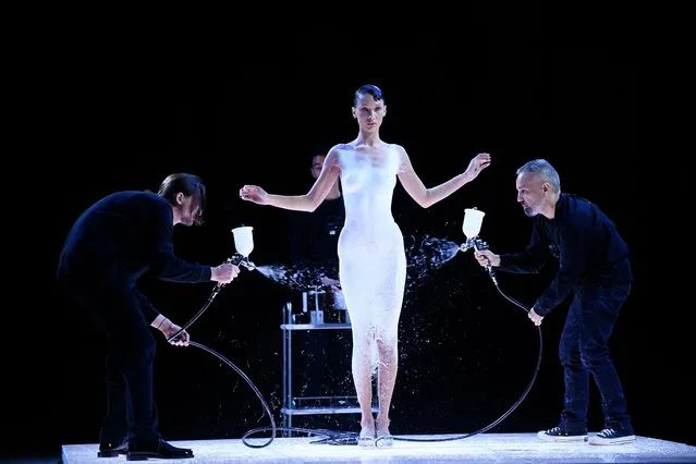 American model Bella Hadid is dressed by spraying Fabrican Spray-on fabric during the Coperni Spring-Summer 2023 fashion show as part of the Paris Womenswear Fashion Week, in Paris, on September 30, 2022. Dr Manel Torres (R), is the managing director of Fabrican Ltd and inventor of the spray-on fabric, used to create a  minimalist Coperni slip dress directly onto Hadid's body. (Photo by Julien de Rosa/AFP Photo)