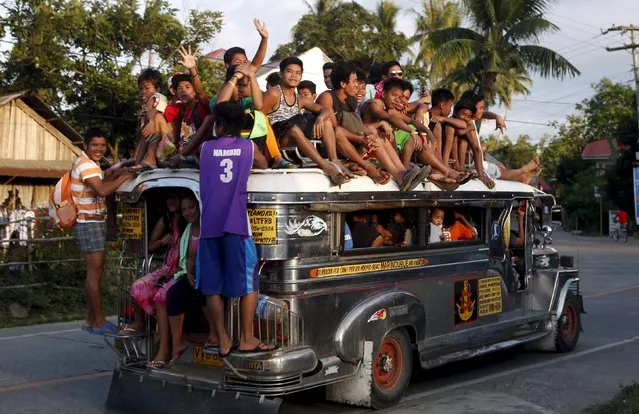 Residents ride on top of an overcrowded "Jeepney", a locally manufactured public transport, along a highway in Mogpog town on Marinduque island in central Philippines April 8, 2015. (Photo by Erik De Castro/Reuters)