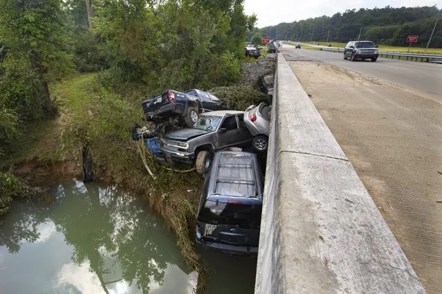 Cars are stacked on top of each other at a Hwy. 13 bridge over Blue Creek after being swept up in flood water, Monday, August 23, 2021, in Waverly, Tenn. Heavy rains caused flooding in Middle Tennessee days ago and have resulted in multiple deaths as homes and rural roads were washed away. (Photo by John Amis/AP Photo)
