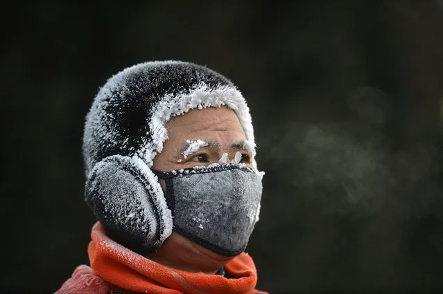 A resident is covered in frost while exercising outdoors during cold weather in Shenyang, in China's northeast Liaoning province on December 20, 2023. (Photo by AFP Photo/China Stringer Network)