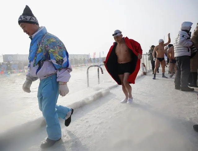 A swimmer follows an official from the organiser to his platform on a pool carved into the thick ice covering the Songhua River during the Harbin Ice Swimming Competition in the northern city of Harbin, Heilongjiang province January 5, 2014. (Photo by Kim Kyung-Hoon/Reuters)