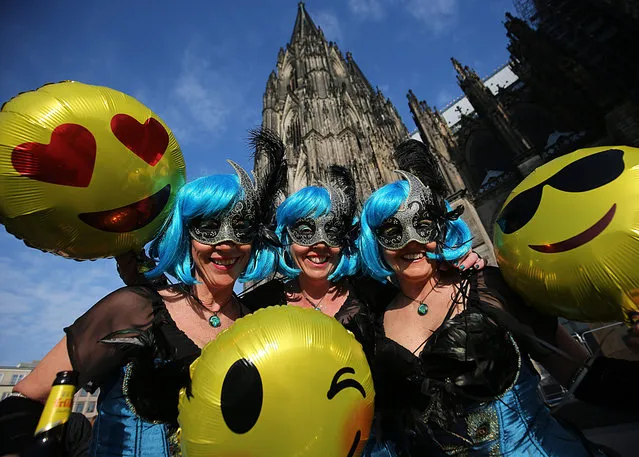 Carnivalists with balloons stand in front of the cathedral. Weiberfastnacht traditionally heralds the beginning of street carnival in orth Rhine-Westphalia, Köln on February 28, 2019. (Photo by Oliver Berg/dpa)