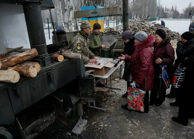 Local residents receive hot tea at an emergency center after shelling hit supply infrastructure in the government-held industrial town of Avdiyivka, Ukraine, February 3, 2017. (Photo by Gleb Garanich/Reuters)