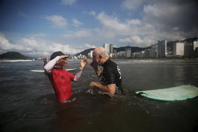 Teacher Denise, 55, gives a surfing lesson to Claudines Garcia (R), 64, during their morning surf class in Santos, Sao Paulo state, Brazil March 17, 2016. (Photo by Nacho Doce/Reuters)