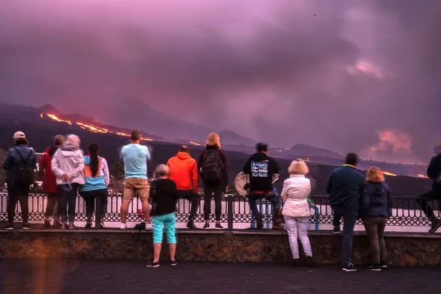People gather to watch the eruption of the Cumbre Vieja volcano from the Tajuya viewpoint, on November 4, 2021, in Dos Pinos, La Palma, Santa Cruz de Tenerife, Canary Islands, Spain. The Cumbre Vieja volcano, which erupted over a month ago, continues to be fully active with an increase in tremors and sulphur dioxide emissions. (Photo by k*ke Rincon/Europa Press via Getty Images)