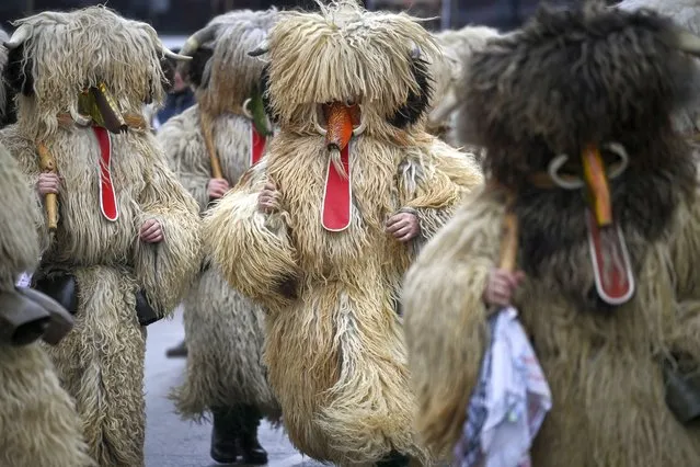 Dancers, known as Kukeri, wearing costumes perform during the International Festival of the Masquerade Games in Pernik, near Sofia on January 28, 2023. The three-day festival, which started on January 27, has participants wearing multi-coloured masks, covered with beads, ribbons and woolen tassels while the main dancer, ladened with bells to drive away sickness and evil spirits, sways like a wheat spikelet heavy with grain. (Photo by Nikolay Doychinov/AFP Photo)