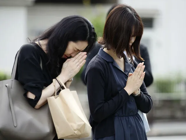 Women pray for the victims near the site of a knife attack in Kawasaki, near Tokyo Wednesday, May 29, 2019. A man carrying a knife in each hand attacked a group of schoolgirls waiting at a bus stop just outside Tokyo Tuesday. (Photo by Hiroki Yamauchi/Kyodo News via AP Photo)