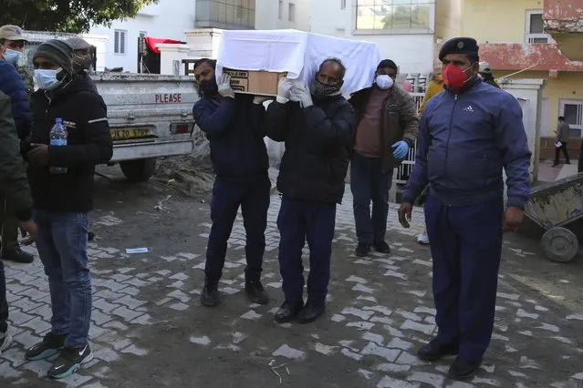 Health workers carry the coffin of a victim, who died in a stampede at the Mata Vaishnav Devi shrine, at a hospital in Katra, India, Saturday, January 1, 2022. A stampede at a popular Hindu shrine in Indian-controlled Kashmir killed at least 12 people and injured 13 others on New Year’s Day, officials said. (Photo by Channi Anand/AP Photo)