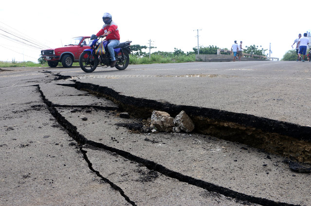 Vehicles drive by a fracture on a road caused by a 7.8 earthquake in Manta, Ecuador, Sunday, April, 17, 2016. A powerful, 7.8-magnitude earthquake shook Ecuador's central coast on Saturday, killing hundreds and spreading panic as it collapsed homes. (Photo by Patricio Ramos/AP Photo)