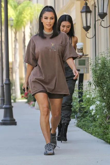 Kim Kardashian leaves a meeting in Calabasas, CA on June 25, 2019 with an assistant as she rocks an oversized Travis Scott tour t-shirt and Adidas Yeezys. (Photo by Backgrid USA)