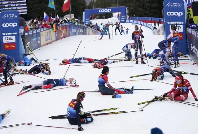 Participants recover at the finish line during the Women's Mass Start Free 10km event at the Tour de Ski in Val di Fiemme, Trento, Italy, Tuesday, January 4, 2022. (Photo by Giovanni Auletta/AP Photo)