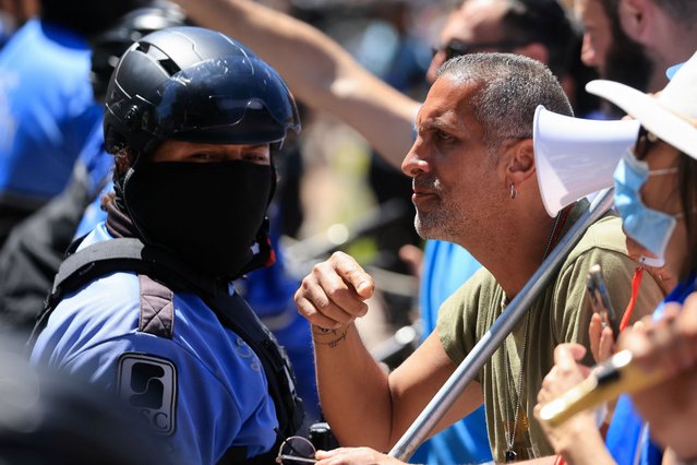 A pro-Israel counter-protester stands next to security personnel during a demonstration by protesters in support of Palestinians in Gaza, amid the ongoing conflict between Israel and the Palestinian Islamist group Hamas, at the University of California Los Angeles (UCLA) in Los Angeles, California on April 28, 2024. (Photo by David Swanson/Reuters)