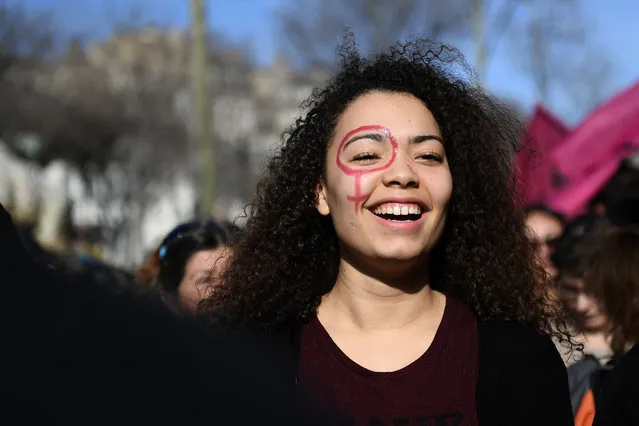 A woman with the female gender pictogram made up on her face attends a demonstration as part of the 40th International Women's Day on March 8, 2017 in Marseille. (Photo by Anne-Christine Poujoulat/AFP Photo)