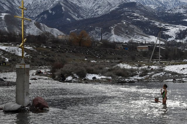 Orthodox believers plunge into the icy waters of the Kara-Balta river during the celebration of the Epiphany holiday near the village of Sosnovka, some 90 kms from Bishkek, on January 19, 2024. Among Orthodox Christians, the feast of Epiphany celebrates the day the spirit of God descended upon believers in the shape of a dove during Jesus Christ's baptism in the river Jordan. (Photo by Vyacheslav Oseledko/AFP Photo)