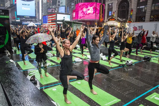 People participate in a mass yoga session celebrating Solstice in Times Square, Friday, June 21, 2019. (Photo by Natan Dvir)