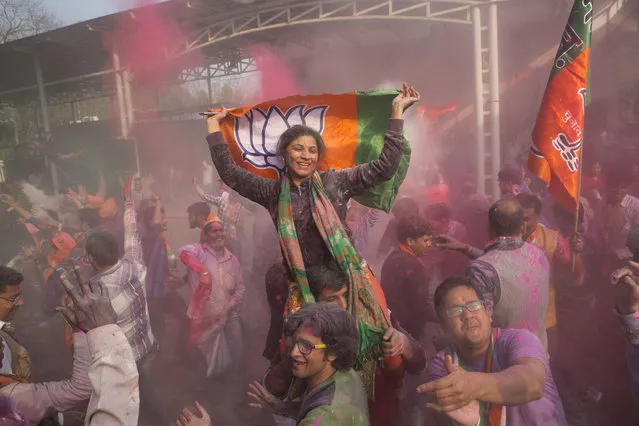 Bharatiya Janata Party supporters dance and throw colored powder as they celebrate at the party headquarters in New Delhi, India, Saturday, March 11, 2017. (Photo by Tsering Topgyal/AP Photo)