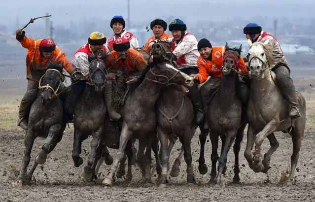 Kyrgyz riders play the traditional Central Asian sport of Kok-Boru (Gray Wolf) or Buzkashi (Goat Grabbing) in the village of Sokuluk, some 20 kilometres from Bishkek, on March 30, 2021. Kok-Boru is a traditional horse game where mounted players compete for points by manoeuvering a stuffed sheepskin into the opponents goalpost. (Photo by Vyacheslav Oseledko/AFP Photo)