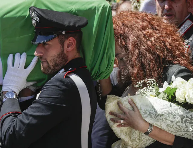 Carabinieri officer Mario Cerciello Rega's wife, Rosa Maria, right, follows the coffin containing the body of her husband during his funeral in his hometown of Somma Vesuviana, near Naples, southern Italy, Monday, July 29, 2019. Two American teenagers were jailed in Rome on Saturday as authorities investigate their alleged roles in the fatal stabbing of the Italian police officer on a street near their hotel. (Photo by Andrew Medichini/AP Photo)