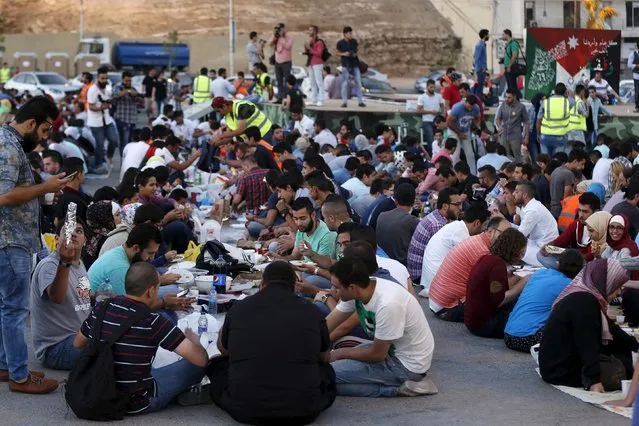 People eat their Iftar (breaking of fast) during a local initiative called “Let's Have Iftar Together” during the holy fasting month of Ramadan in Amman, Jordan June 27, 2015. (Photo by Muhammad Hamed/Reuters)