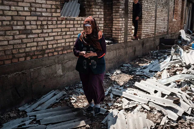 A Kyrgyz woman stands in front of her destroyed house in the village of Maksat on May 2, 2021. Kyrgyzstan's leader Sadyr Japarov called citizens to respect a peace deal signed with Tajikistan after the pair's heaviest border clashes left at least 34 Kyrgyz citizens dead and said a ceasefire with Tajikistan was holding on May 2, as it accused citizens from its Central Asian neighbour of crimes during the pair's worst clashes at their contested border in decades. The Kyrgyz interior ministry said that casualties on its side had risen to over 160 with 34 deaths, 31 of whom were civilians. (Photo by Danil Usmanov/AFP Photo)