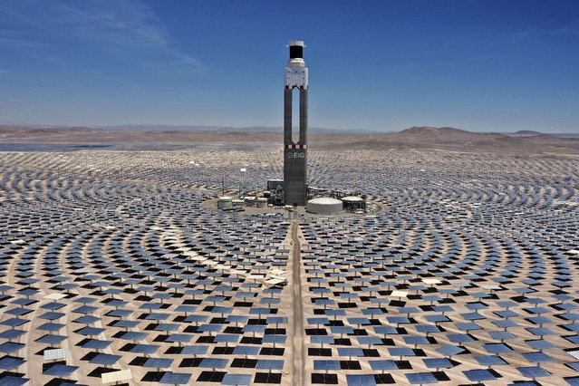 Aerial view of Cerro Dominador, the first thermosolar power plant in Latin America, in Antofagasta, Chile, taken on November 23, 2023. In the Atacama Desert, the driest desert in the world, located in northern Chile, a 240-meter solar thermal tower surrounded by mirrors is operating as a symbol of the biggest energy revolution against climate change in Latin America. The imposing construction of Cerro Dominador, which Chileans compare to the tower of Sauron from “The Lord of the Rings”, is one of the pillars of the ambitious green energy program that aims to completely replace fossil fuels by 2040. (Photo by Pablo Cozzaglio/AFP Photo)
