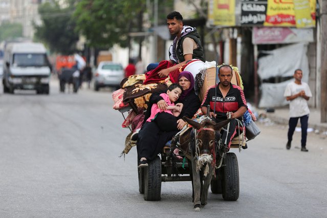 Palestinians travel in a donkey-drawn cart loaded with their belongings as they flee Rafah due to an Israeli military operation, in Rafah, in the southern Gaza Strip, on May 28, 2024. (Photo by Hatem Khaled/Reuters)