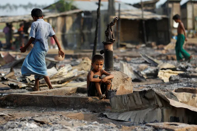 A boy sit in a burnt area after fire destroyed shelters at a camp for internally displaced Rohingya Muslims in the western Rakhine State near Sittwe, Myanmar May 3, 2016. (Photo by Soe Zeya Tun/Reuters)