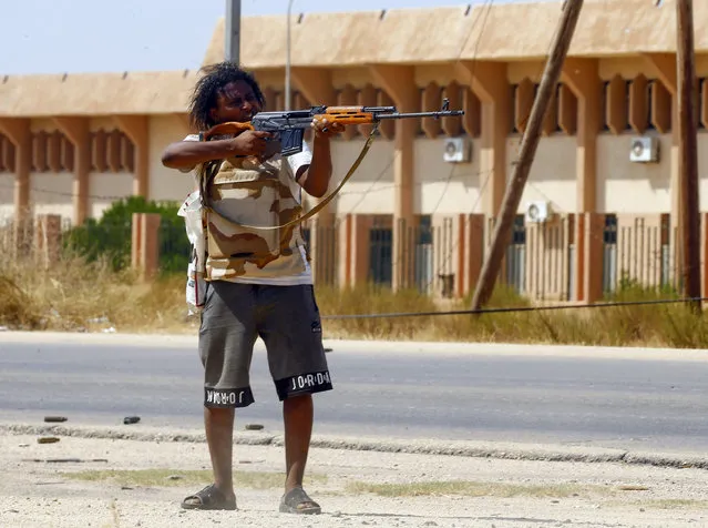 A fighter loyal to the UN-recognised Government of National Accord (GNA) points his gun toward enemy lines during clashes with forces loyal to strongman Khalifa Haftar, in Espiaa, about 40 kilometers (25 miles) south of the Libyan capital Tripoli on August 21, 2019. (Photo by Mahmud Turkia/AFP Photo)
