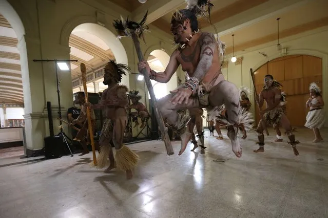 Rapa Nui natives perform a dance in front of a Moai statue (unseen) from Easter Island while it is displayed at the Natural History Museum before returning to the island, in Santiago, Chile, February 21, 2022. (Photo by Ivan Alvarado/Reuters)